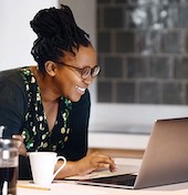African American woman smiling looking at laptop