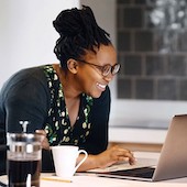 Woman smiling looking at her checking account on laptop
