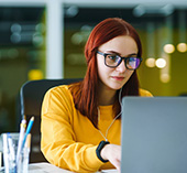 Student sitting at computer applying for student loans.