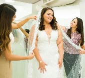 Woman standing in front of mirror in wedding dress.