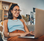 Woman sitting at laptop, opening a high-yield savings account.