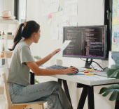 Woman sitting at computer, reviewing finances.