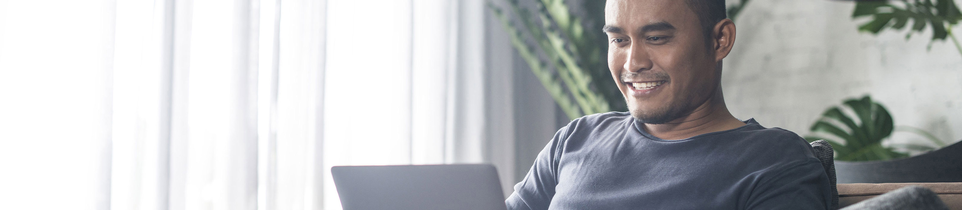 Man sitting with his laptop and smiling